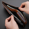 A hand is opening a brown leather wallet to show multiple cards and cash inside.