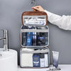 A brown cosmetic organizer bag with clear compartments and a white sponge is being held by a hand.