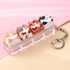 A collection of acrylic kawaii cat keycaps and fidget toys in various orange, white, and black leopard print designs displaye