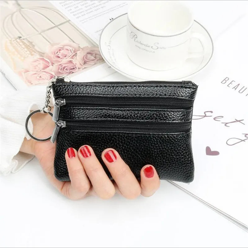 A black quilted PU leather clutch wallet with a silver chain is held by a hand next to a white cup and some pink roses.