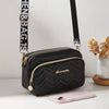 Black quilted crossbody camera bag with a gold letter strap next to a pink smartphone.