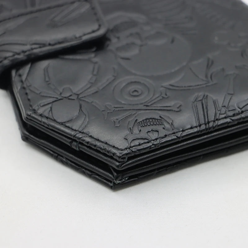 Black leather wallet with vintage embossed design featuring skulls and floral motifs.