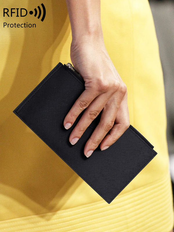 A hand holds a black RFID protection bi-fold wallet against a yellow garment.