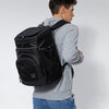 A man is shown wearing a black insulated thermal cooler backpack and a gray hoodie.