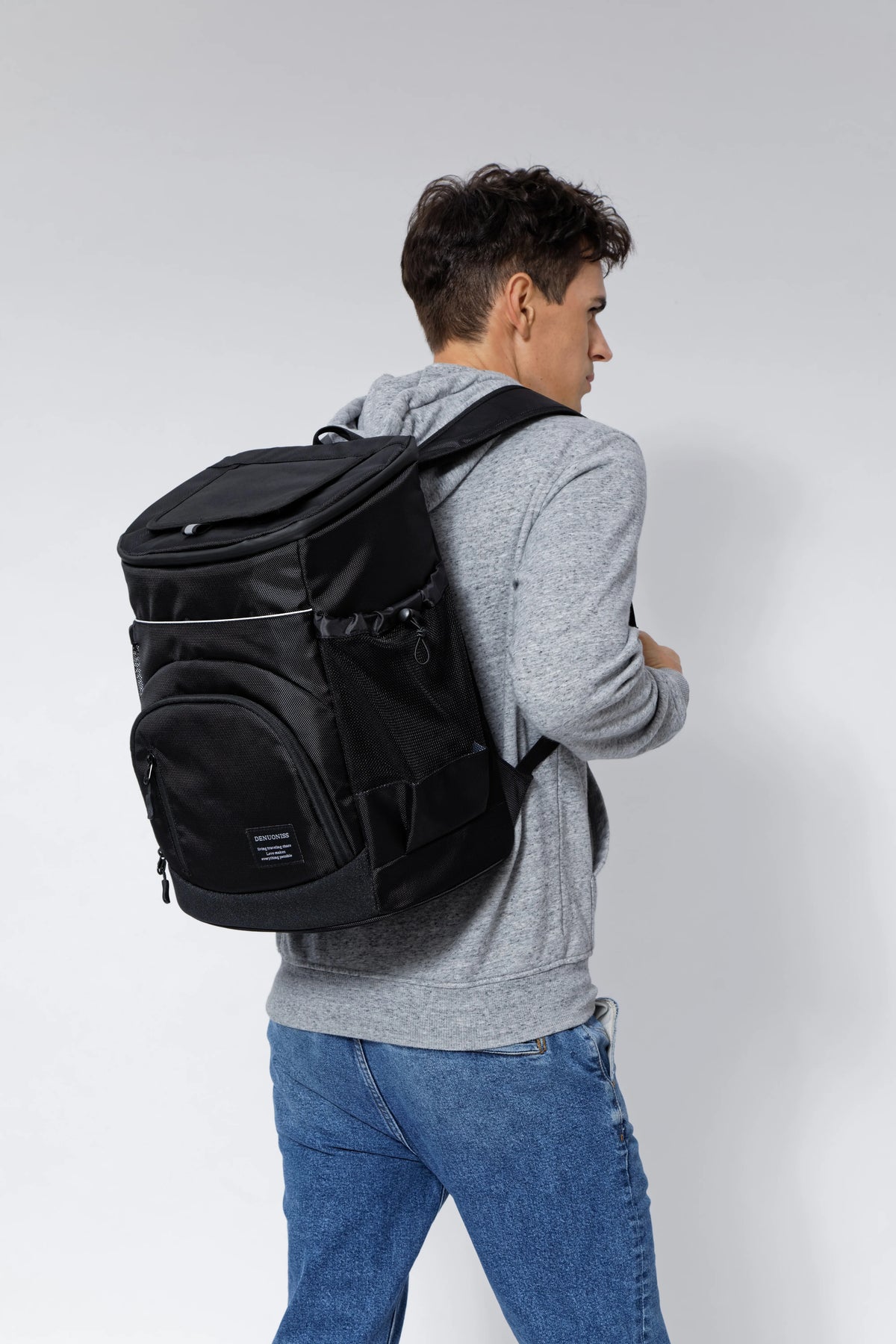 A man is shown wearing a black insulated thermal cooler backpack and a gray hoodie.