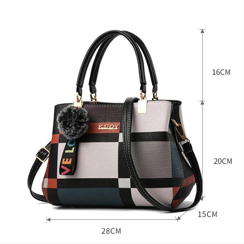 Sac bandoulière en cuir PU à carreaux noir et gris avec un charm pompon, vue de profil.