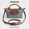A light blue leather mini bag with brown leather straps and a matching strap set.