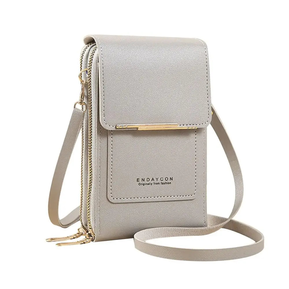A light beige RFID-protected touch screen crossbody bag with gold hardware and a leather strap.