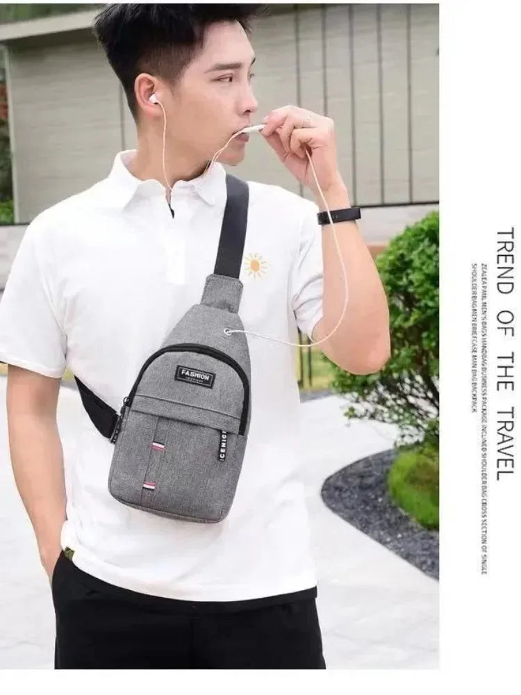 A man wearing a white shirt holds a gray waterproof crossbody fanny pack and uses an earbud.