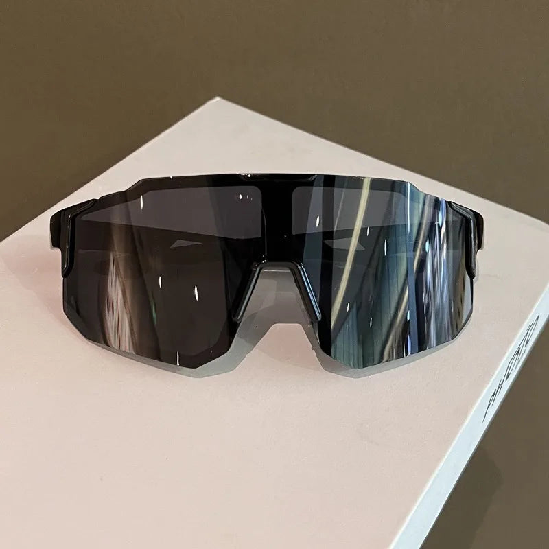 Un par de gafas de sol oscuras y tintadas para ciclismo descansando sobre una superficie blanca.