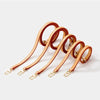 A set of genuine Vachetta leather handbag straps with gold-tone buckles arranged diagonally.