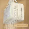 A cream-colored waterproof storage pouch with a mesh drainage zone and zipper details.