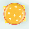 A yellow leather card holder wallet with a round, perforated design and a red trim.