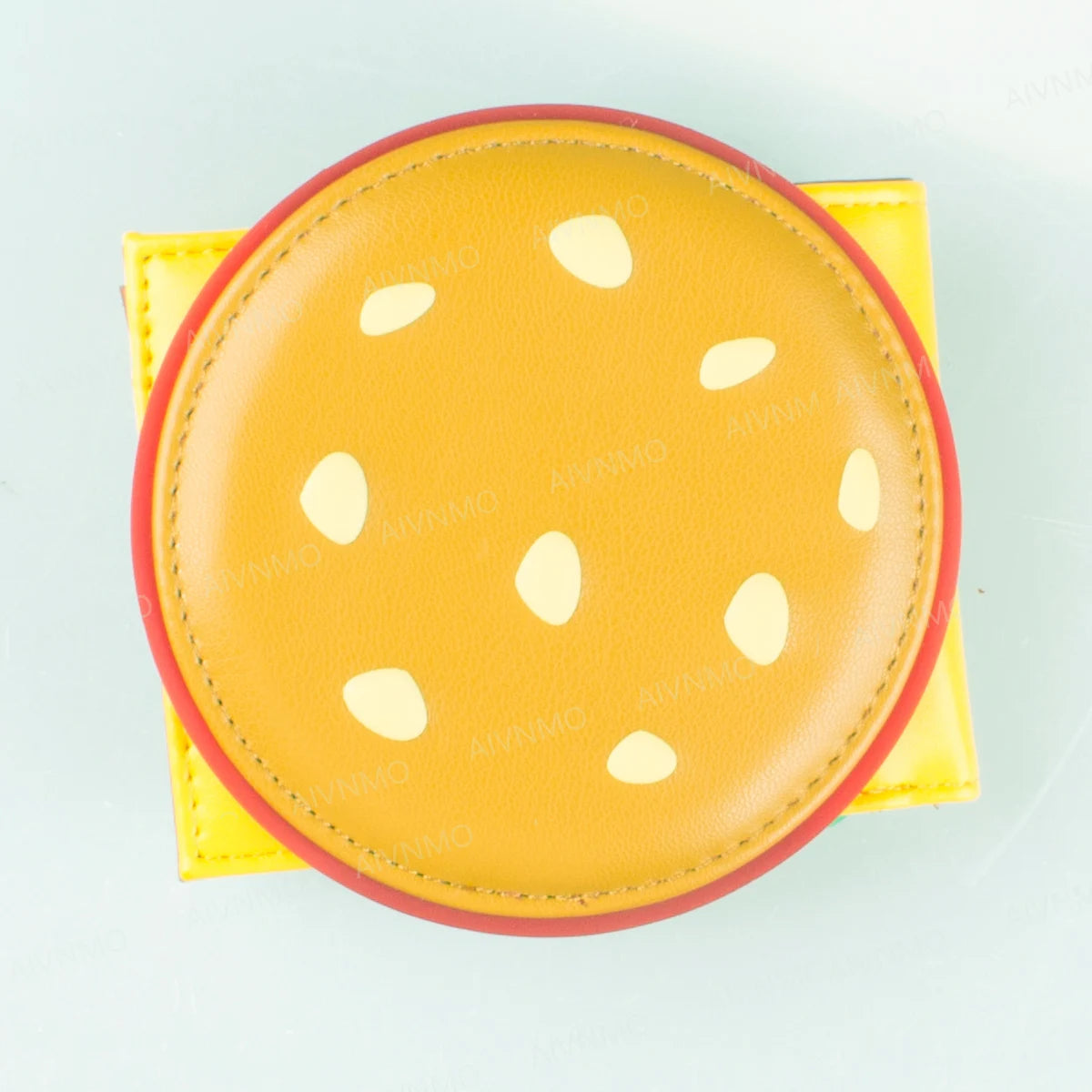 A yellow leather card holder wallet with a round, perforated design and a red trim.