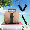 A tan luggage bag with a black strap is placed on top of a white suitcase, with a pair of black magnifying glasses nearby.