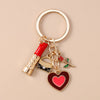 A gold-toned enamel heart keychain with a red and pink design attached to a circular keyring.