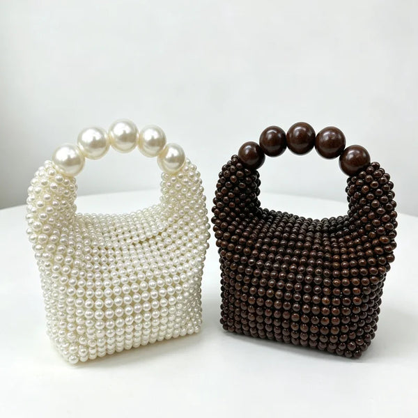 Pochette à perles de nacre blanche et pochette à perles marron foncé côte à côte.