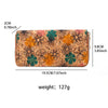 A rectangular wallet made of wood-grain leather featuring a floral pattern in orange, green, and brown tones.