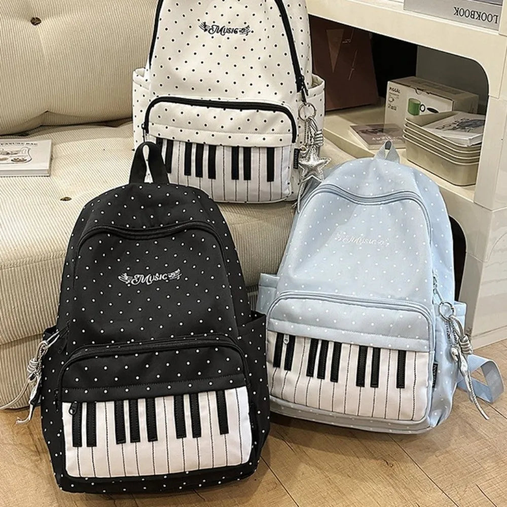 Collection de sacs à dos à motif pois et clavier de piano en noir, blanc et bleu clair.