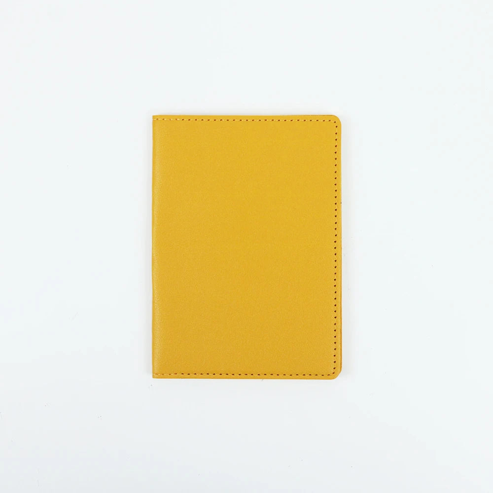 A plain yellow PU leather passport holder with stitched edges.