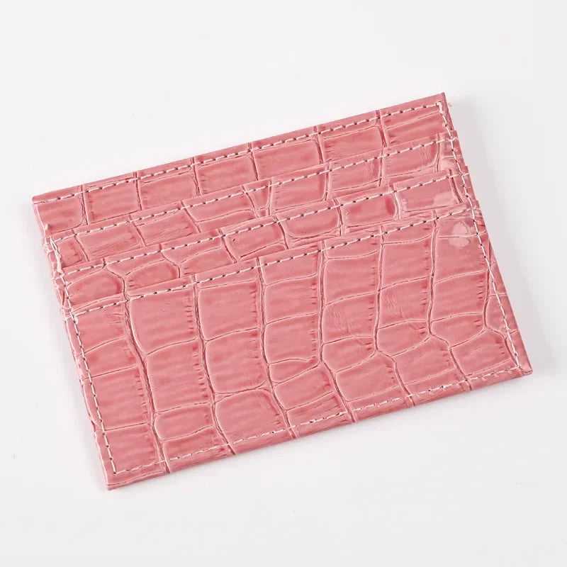 A pink crocodile embossed slim PU leather card holder wallet for women.