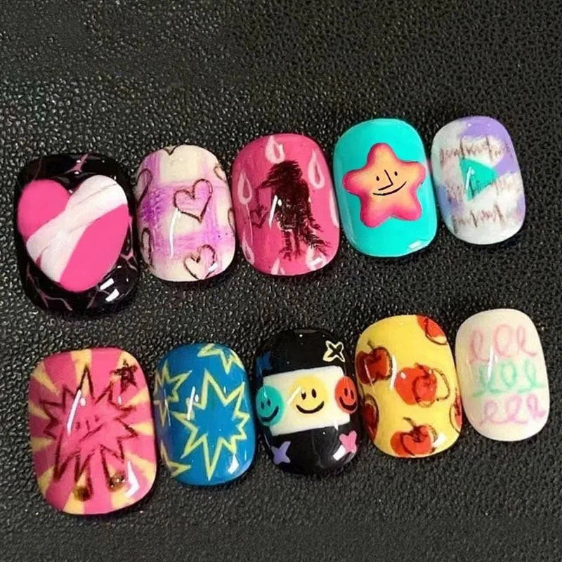A collection of colorful cartoon press-on nails featuring various designs and glitter finishes.