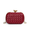 A deep red handwoven clutch evening bag with a woven texture and gold-toned hardware.