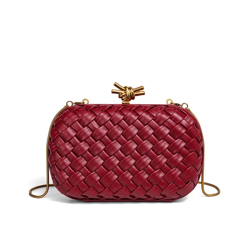 A deep red handwoven clutch evening bag with a woven texture and gold-toned hardware.