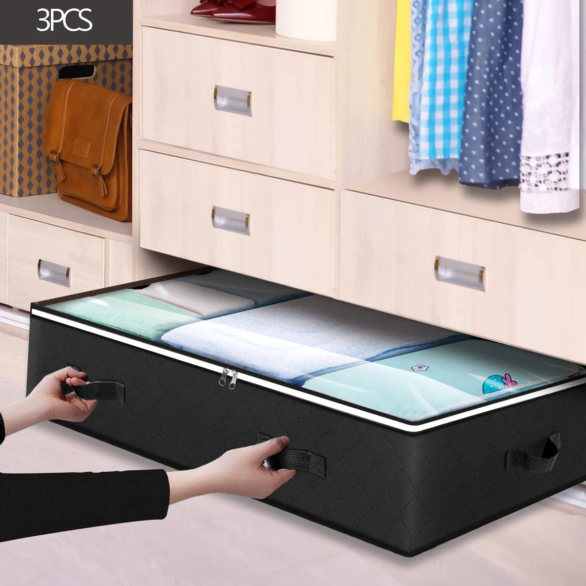 A person is lifting a black under bed storage organizer bin with a clear lid and white bedding inside.
