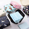 Various pink and blue fabric pouches and a black storage case filled with light blue sanitary pads.