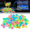 A collection of brightly colored glow-in-the-dark solar pebbles in various shades of green, yellow, pink, and blue.