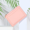 A pink PU leather mini card holder wallet with a zipper, shown against a light background with green leaves.