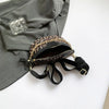 Leopardenmuster-Crossbody-Tauschtasche mit goldfarbenem Kettenriemen, liegt auf einem grauen Blazer.