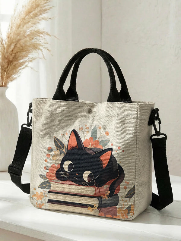 A beige canvas tote bag featuring a floral cat print with black straps.