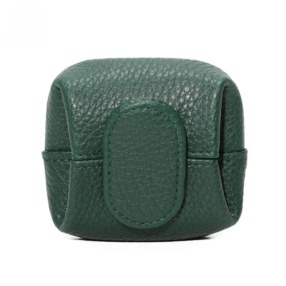 A dark green compact coin purse with a textured leather finish and snap closure.