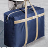 A navy blue foldable waterproof storage bag with tan straps resting on a gray tiled surface.
