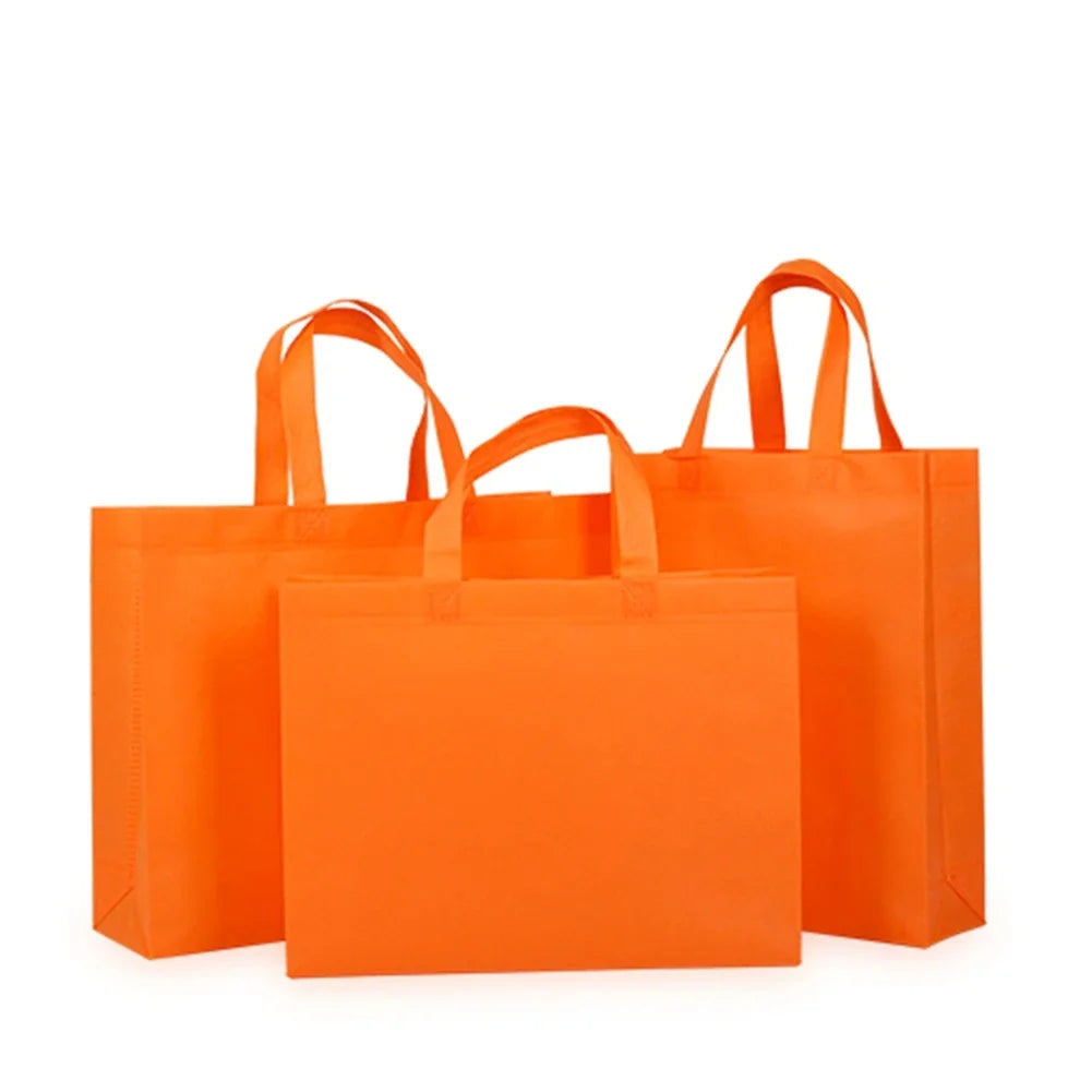 Ein Set von zehn leuchtend orangefarbenen, nicht gewebten Einkaufstaschen vor weißem Hintergrund.