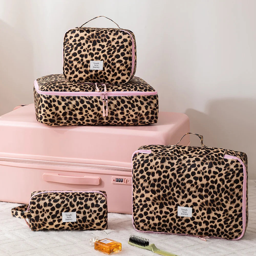 A leopard print large capacity waterproof travel makeup organizer bag in pink and black resting on a pink box.