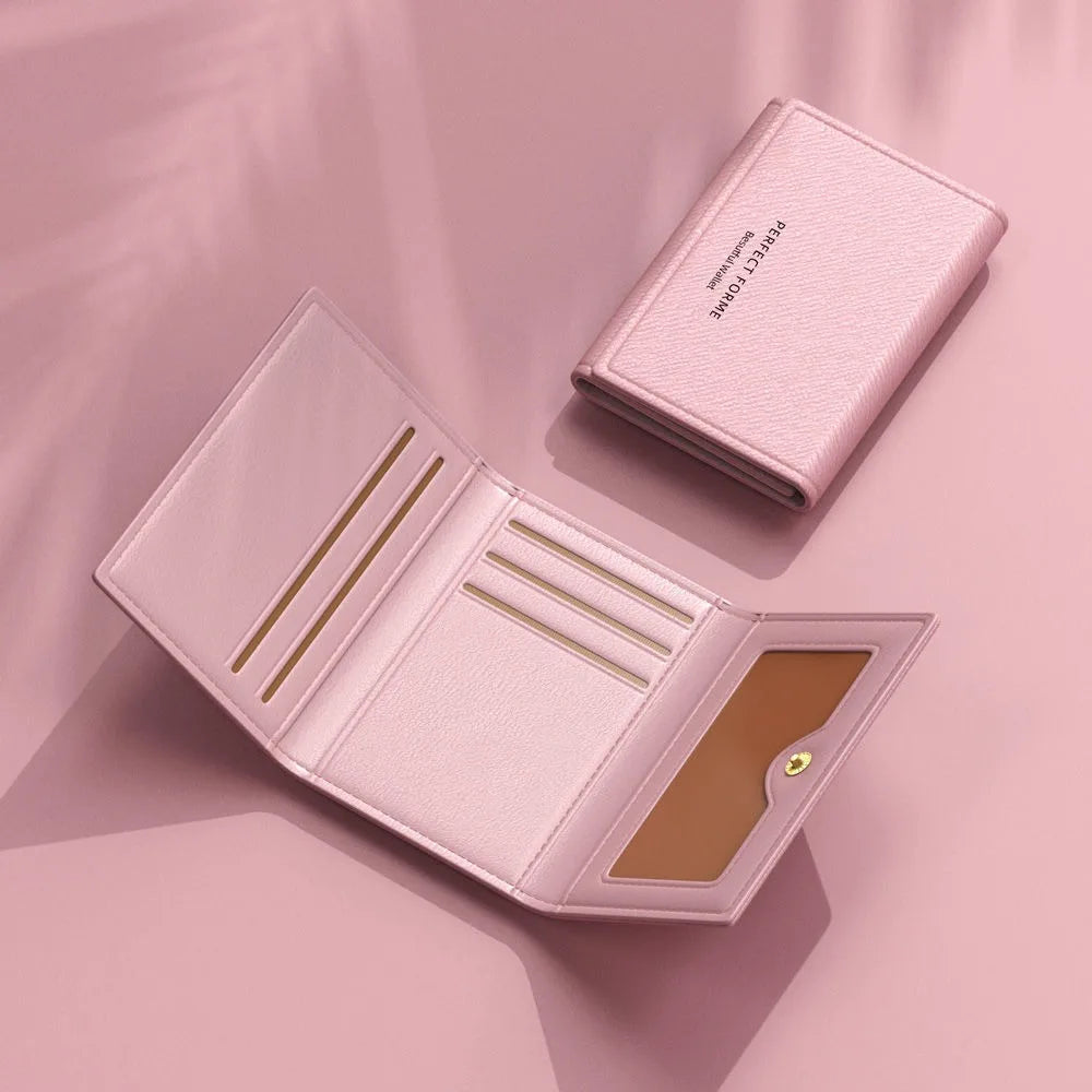 Cartera de cuero rosa de varias tarjetas abierta, mostrando compartimentos interiores y exterior texturizado.