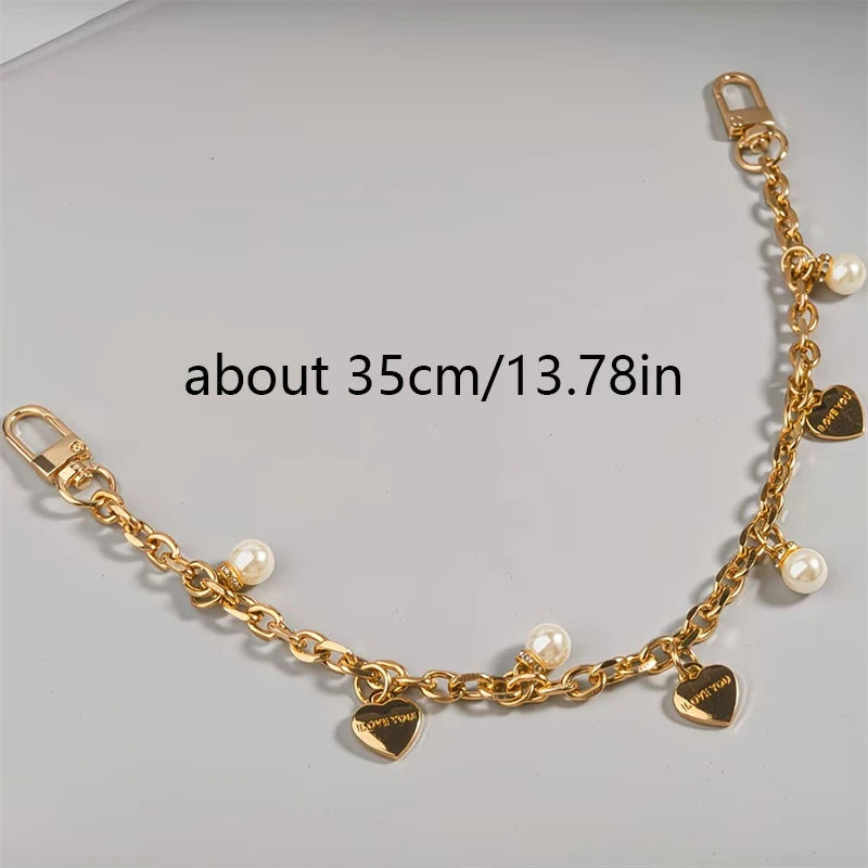 Goldfarbener Kettenriemen mit Perlenakzenten und Herzcharm, ca. 35 cm lang.