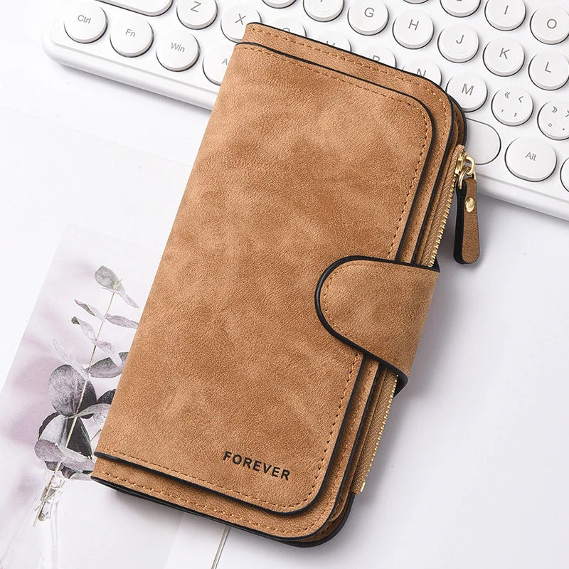 A brown leather zipper wallet with a stitched flap and gold hardware resting on a white surface.