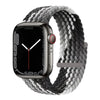 A black Apple Watch is shown with a gray braided stretch band wrapped around it.