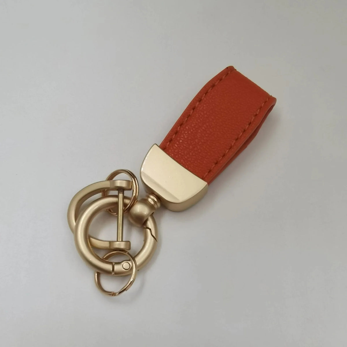 Echtes Leder-Schafsfell Auto-Schlüsselanhänger mit rötlich-braunem Lederriemen und Messing-Hardware.