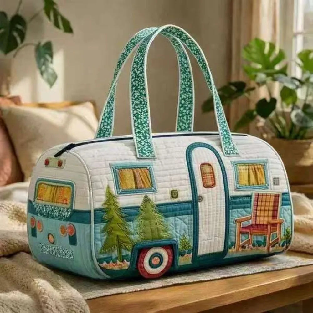 A light blue quilted travel duffel bag with a green trim and decorative window details resting on a wooden surface.