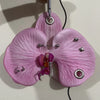 A realistic pink orchid flower keychain with purple accents hanging from a ring.
