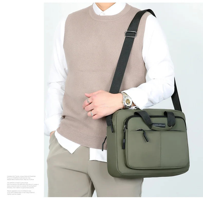 Un hombre con suéter beige y camisa blanca sostiene una bolsa de mensajero verde oliva oscuro.