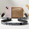 Beige quilted crossbody camera bag with black and gold letter strap next to an iPhone.
