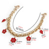 Gold metal purse chain strap with floral charms shown against a white background.