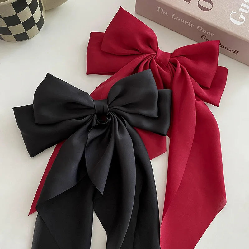 A set of elegant silk bow hair clips in black and red satin fabric.