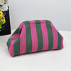 A pink and green striped knit cloud makeup bag lying on a white surface.